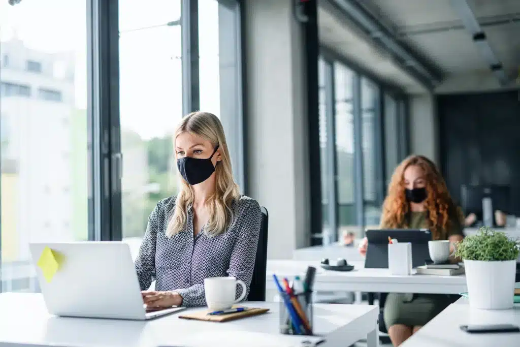 PassportCard/Internationale Krankenversicherung/two-women-wearing-masks-working-in-office